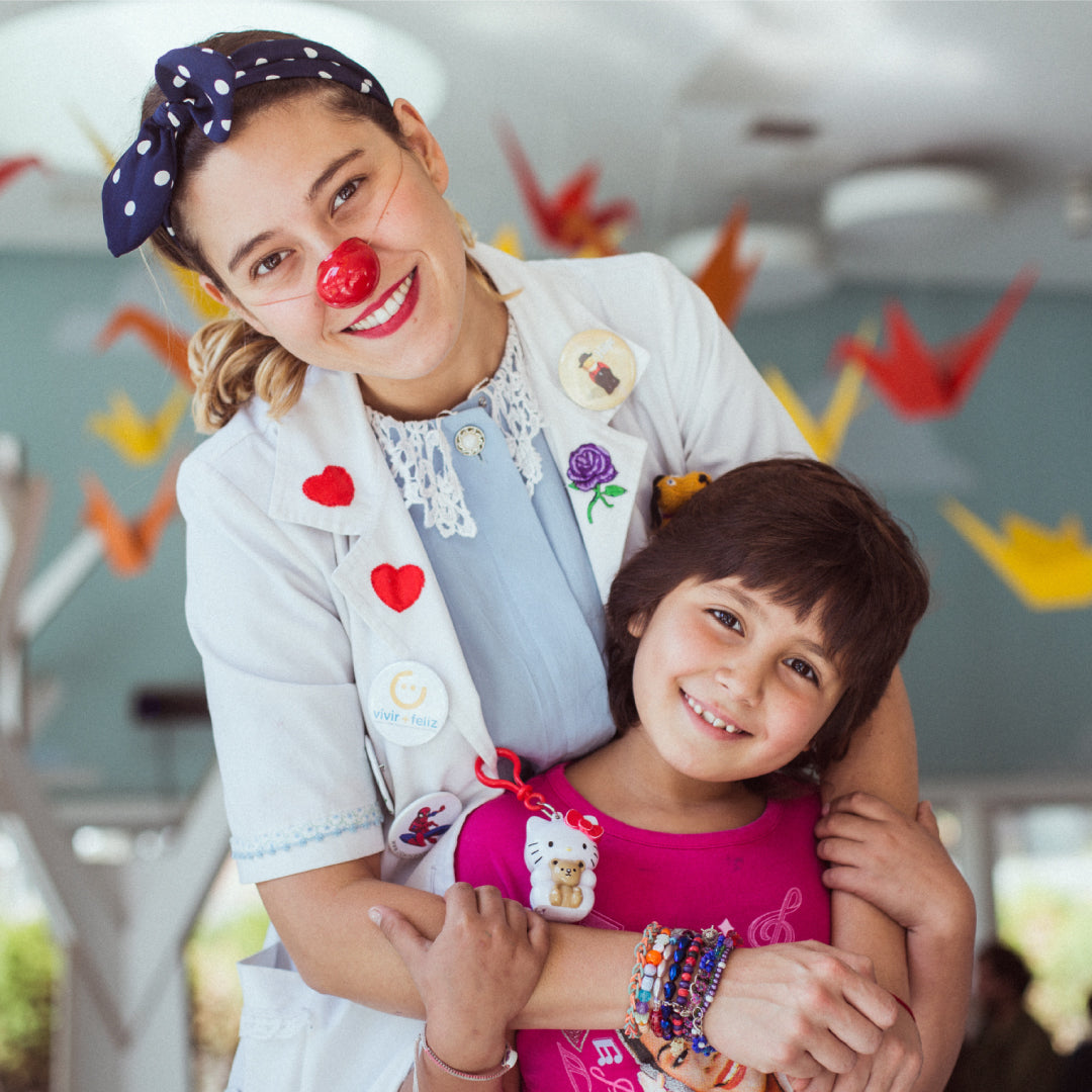 Una profesional de la fundación comparte una sonrisa y un abrazo con una niña.