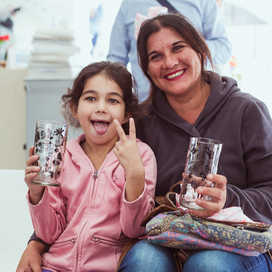 Una niña y una mujer sonríen con sus vasos Green Glass.
